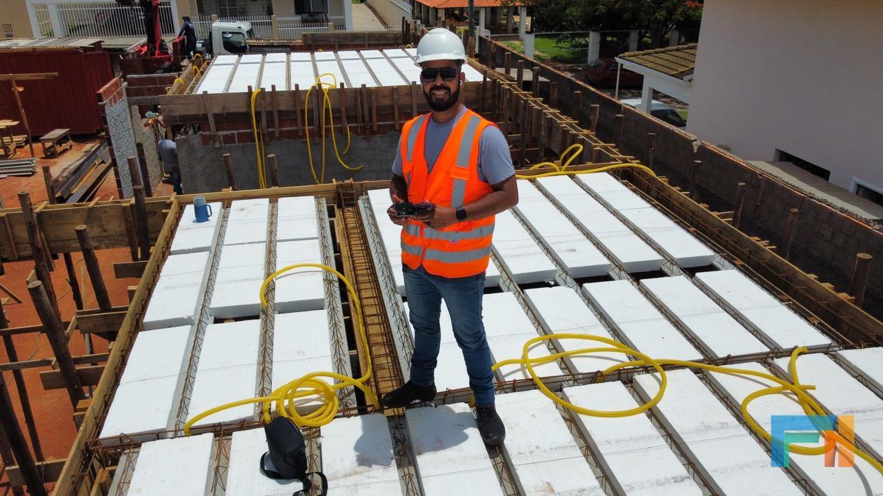 Engenheiro acompanhando a obra com um drone
